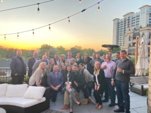 The Planet Group team in Atlanta shown outside on patio gathered in a circle